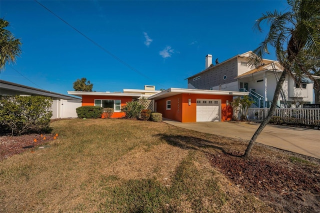 366 La Hacienda Dr, Indian Rocks Beach, FL 33785 - exterior space featuring fence, a front yard, stucco siding, concrete driveway, and an attached garage