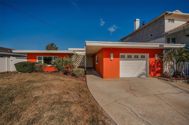 366 La Hacienda Dr, Indian Rocks Beach, FL 33785 - view of front of house featuring a front lawn, fence, stucco siding, concrete driveway, and an attached garage
