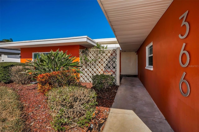 366 La Hacienda Dr, Indian Rocks Beach, FL 33785 - view of side of home featuring stucco siding and a carport