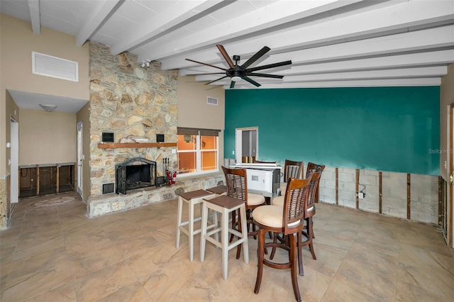 366 La Hacienda Dr, Indian Rocks Beach, FL 33785 - dining room with a ceiling fan, visible vents, beam ceiling, and a fireplace