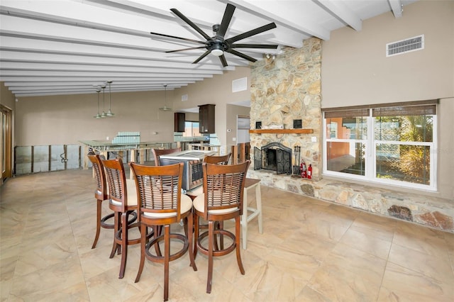 366 La Hacienda Dr, Indian Rocks Beach, FL 33785 - dining room with visible vents, a ceiling fan, beam ceiling, and a stone fireplace