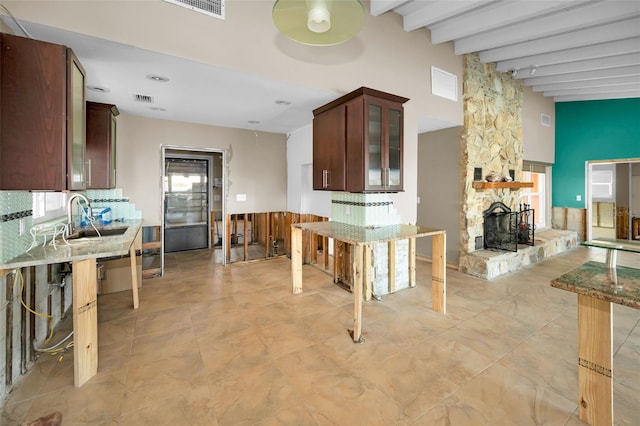 366 La Hacienda Dr, Indian Rocks Beach, FL 33785 - kitchen featuring a sink, glass insert cabinets, a healthy amount of sunlight, and beamed ceiling