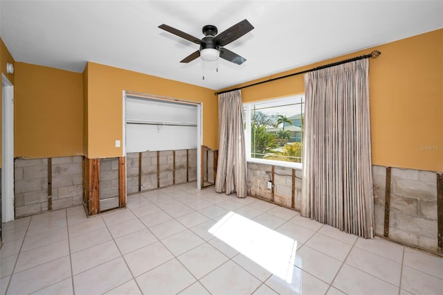 366 La Hacienda Dr, Indian Rocks Beach, FL 33785 - empty room with a ceiling fan, light tile patterned floors, and a wainscoted wall