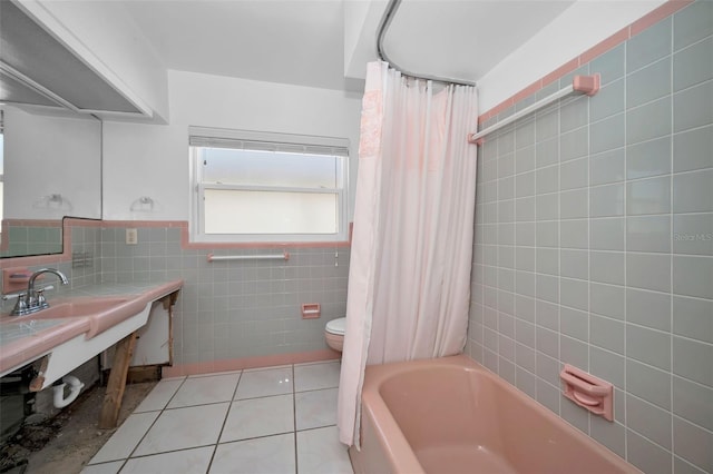366 La Hacienda Dr, Indian Rocks Beach, FL 33785 - bathroom with tile patterned flooring, vanity, toilet, tile walls, and shower / tub combo