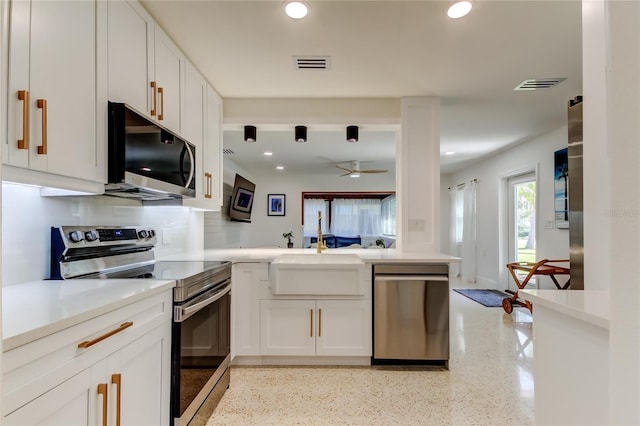 2488 Del Rio Way, Dunedin, FL 34698 - kitchen with stainless steel appliances, a peninsula, recessed lighting, a ceiling fan, and white cabinetry