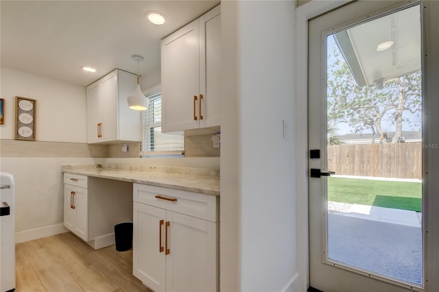 2488 Del Rio Way, Dunedin, FL 34698 - kitchen with white cabinetry, light wood finished floors, recessed lighting, light stone countertops, and hanging light fixtures