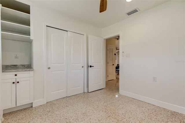 2488 Del Rio Way, Dunedin, FL 34698 - unfurnished bedroom with baseboards, a closet, dark speckled floor, and ceiling fan