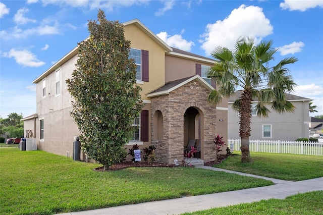 21046 Passive Porch Dr, Land O Lakes, FL 34637 - traditional home with fence, stucco siding, a front yard, and stone siding