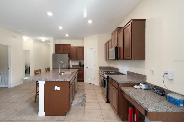 21046 Passive Porch Dr, Land O Lakes, FL 34637 - kitchen featuring a sink, appliances with stainless steel finishes, light tile patterned floors, and a kitchen island with sink
