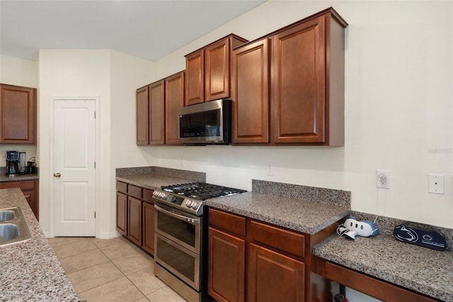 21046 Passive Porch Dr, Land O Lakes, FL 34637 - kitchen with light tile patterned floors and stainless steel appliances
