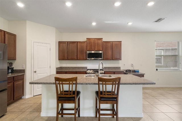 21046 Passive Porch Dr, Land O Lakes, FL 34637 - kitchen with a sink, a breakfast bar area, an island with sink, stainless steel appliances, and visible vents
