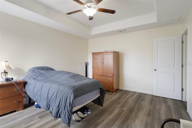21046 Passive Porch Dr, Land O Lakes, FL 34637 - bedroom featuring baseboards, a tray ceiling, wood finished floors, and visible vents