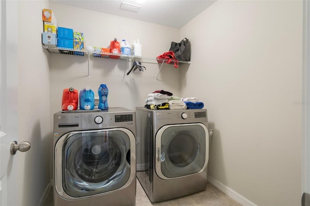 21046 Passive Porch Dr, Land O Lakes, FL 34637 - laundry room featuring laundry area, baseboards, light tile patterned flooring, and washing machine and clothes dryer