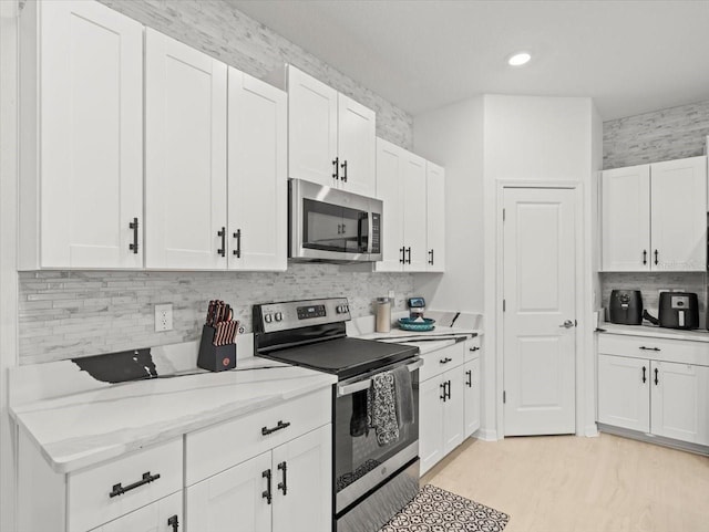 9617 Branching Ship Trce, Wesley Chapel, FL 33545 - kitchen featuring white cabinets, tasteful backsplash, light stone countertops, and stainless steel appliances