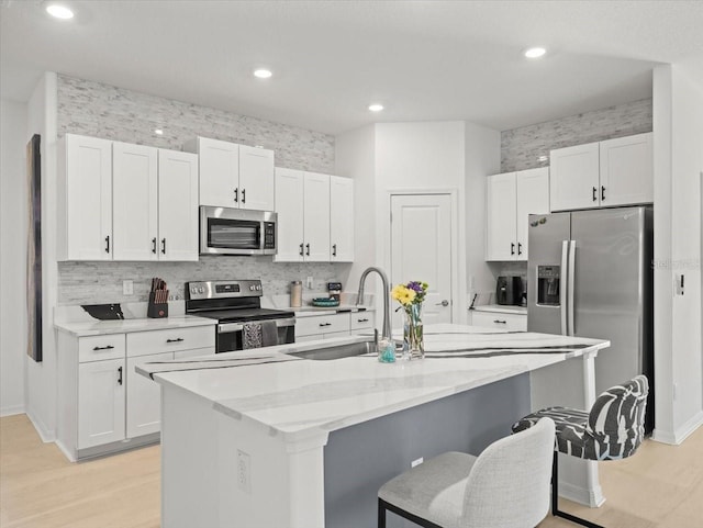 9617 Branching Ship Trce, Wesley Chapel, FL 33545 - kitchen featuring a breakfast bar area, white cabinetry, stainless steel appliances, and a sink