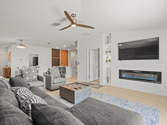 9617 Branching Ship Trce, Wesley Chapel, FL 33545 - living area featuring recessed lighting, a glass covered fireplace, visible vents, and a ceiling fan