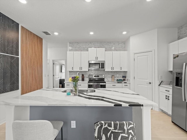 9617 Branching Ship Trce, Wesley Chapel, FL 33545 - kitchen with white cabinets, stainless steel appliances, recessed lighting, and a breakfast bar area