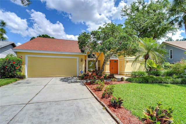 14119 Stonegate Dr, Tampa, FL 33624 - view of front of property featuring a front lawn, concrete driveway, stucco siding, and an attached garage