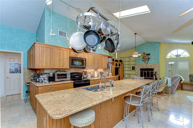 14119 Stonegate Dr, Tampa, FL 33624 - kitchen with a sink, a ceiling fan, black range with electric cooktop, stainless steel microwave, and visible vents