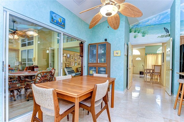 14119 Stonegate Dr, Tampa, FL 33624 - dining area featuring a ceiling fan, a textured wall, high vaulted ceiling, and baseboards