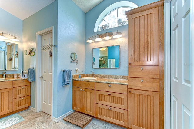 14119 Stonegate Dr, Tampa, FL 33624 - bathroom featuring baseboards, a textured wall, and vanity