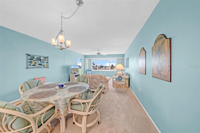 4725 Cove Cir Unit 302, Saint Petersburg, FL 33708 - carpeted dining area with a chandelier, a textured ceiling, baseboards, and a ceiling fan