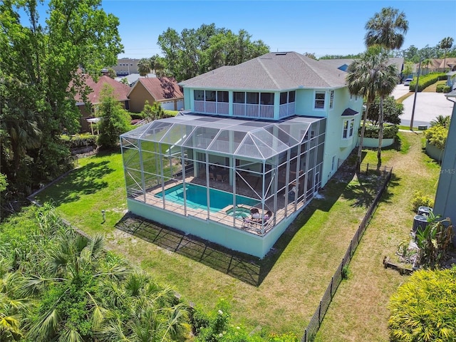 view of swimming pool with fence, a patio area, a lawn, a lanai, and a pool with connected hot tub