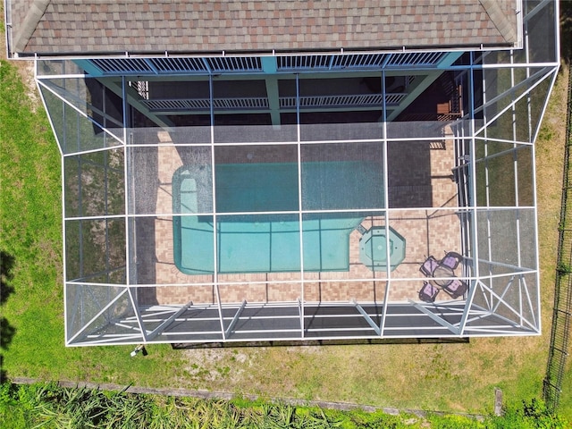 exterior space with glass enclosure and a shingled roof