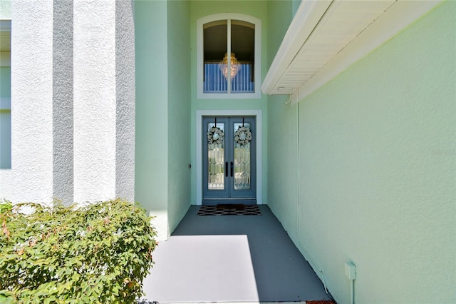 property entrance with stucco siding and french doors