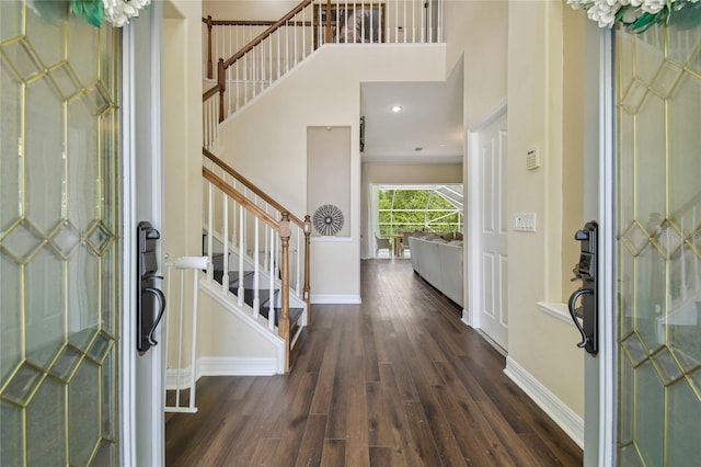 entryway featuring wood finished floors, stairs, and baseboards