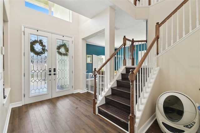 entryway with stairway, a high ceiling, french doors, baseboards, and hardwood / wood-style flooring