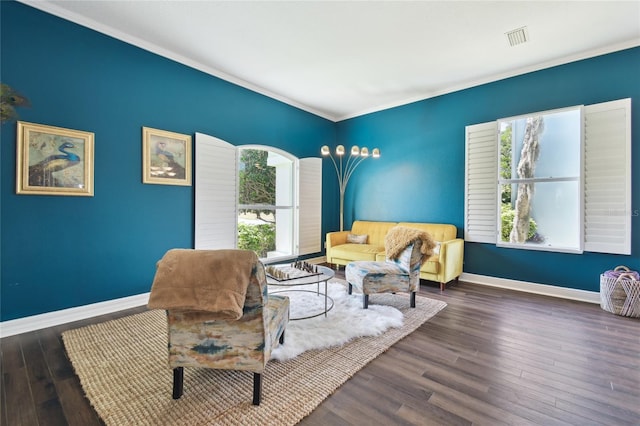 living area featuring wood finished floors, visible vents, baseboards, and ornamental molding