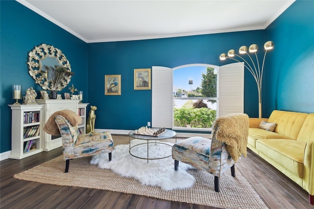 sitting room featuring baseboards, crown molding, and wood finished floors