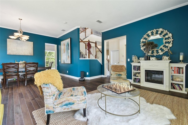 living area with wood finished floors, visible vents, ornamental molding, stairs, and a notable chandelier