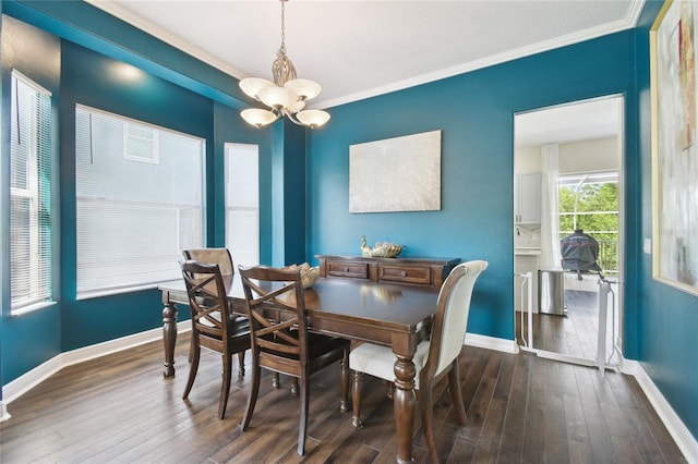 dining area featuring dark wood finished floors, baseboards, ornamental molding, and a chandelier