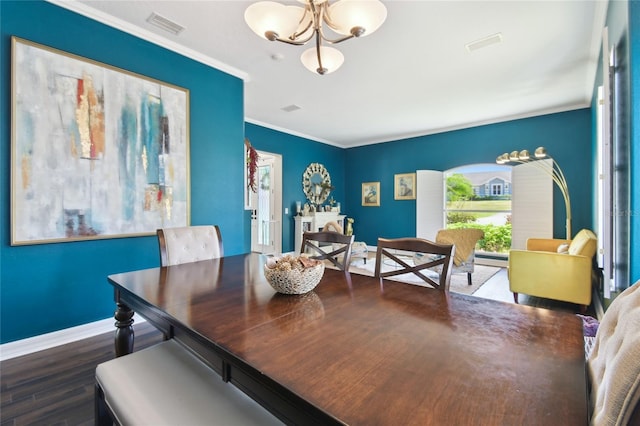 dining room with wood finished floors, an inviting chandelier, baseboards, ornamental molding, and visible vents