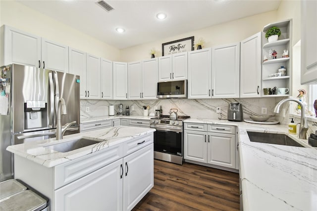kitchen with dark wood-style floors, stainless steel appliances, visible vents, and a sink