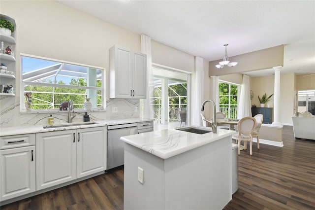 kitchen featuring dark wood-type flooring, dishwasher, a sink, and backsplash
