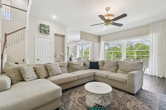 living area with recessed lighting, wood finished floors, a ceiling fan, and stairs
