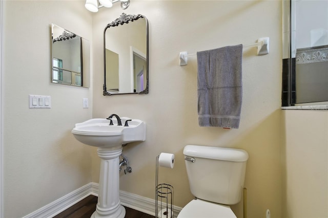 bathroom featuring toilet, wood finished floors, and baseboards