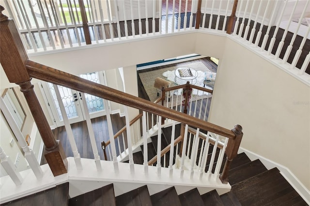 stairway with a high ceiling, a healthy amount of sunlight, and baseboards