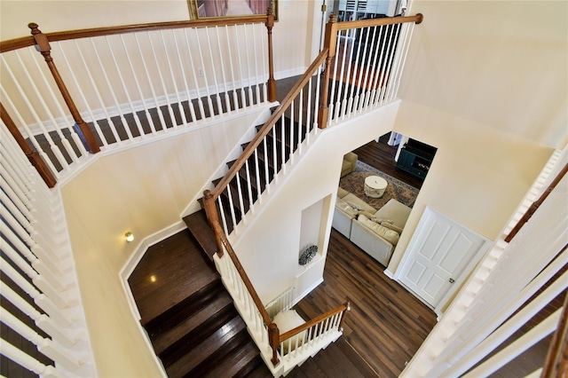 staircase featuring a high ceiling and wood finished floors