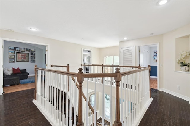 hall featuring wood-type flooring, baseboards, recessed lighting, and an upstairs landing