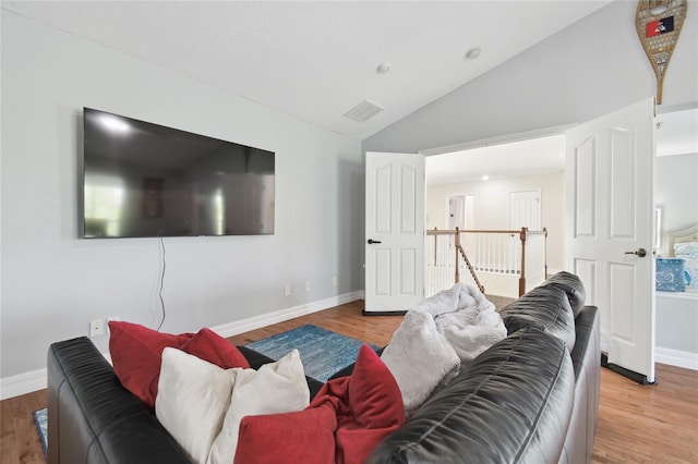 living room featuring vaulted ceiling, baseboards, wood finished floors, and visible vents