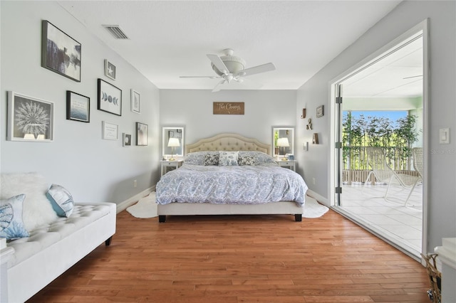 bedroom with visible vents, a ceiling fan, wood finished floors, and access to outside
