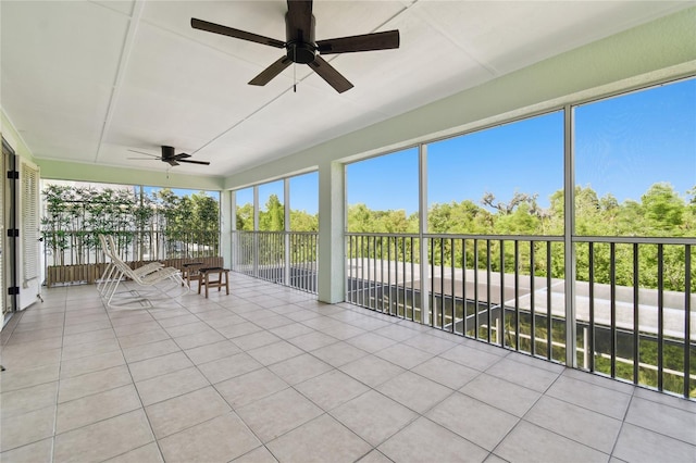 sunroom featuring tile patterned floors and a ceiling fan