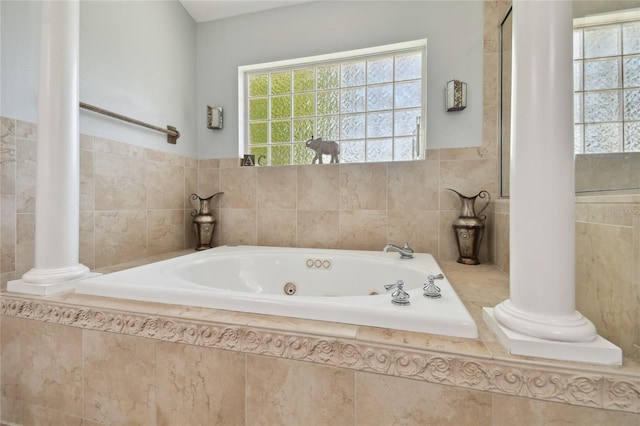 bathroom with a jetted tub and decorative columns