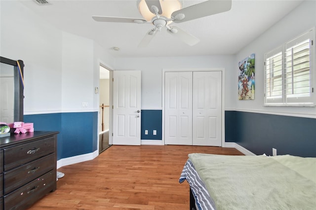 bedroom featuring light wood finished floors, baseboards, a closet, and ceiling fan