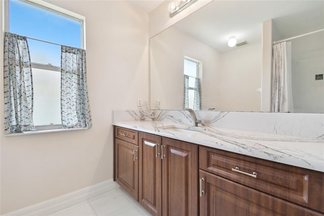 bathroom featuring baseboards, visible vents, vanity, and tile patterned floors
