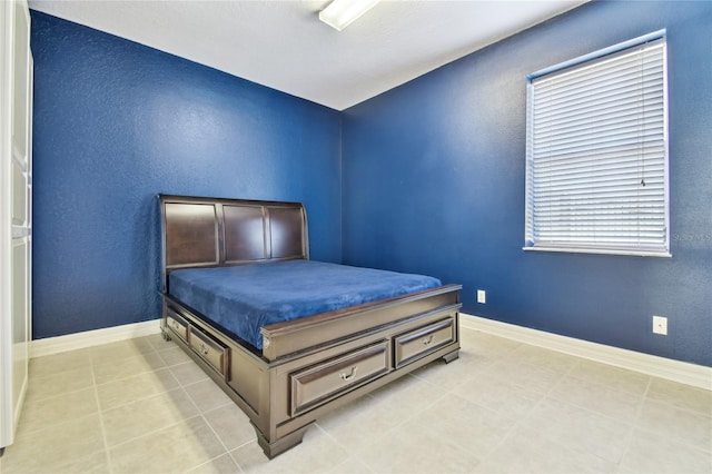 bedroom featuring baseboards and light tile patterned floors